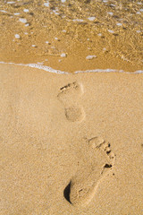 Fototapeta na wymiar Footprints in the sand beach near the sea