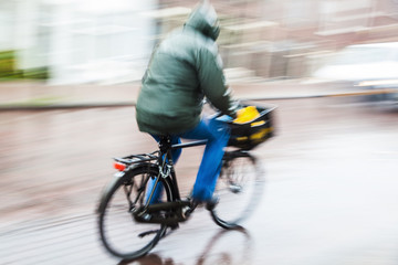 Radfahrer bei Regenwetter in Bewegungsunschärfe