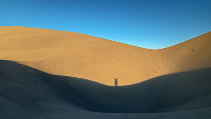 Fototapeta na wymiar Persons shadow on a sand dune in evening