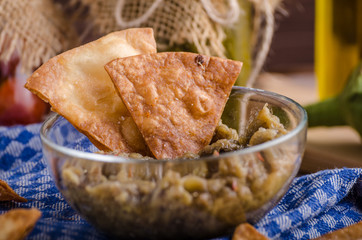 Homemade tortilla chips with garlic and eggplant dip