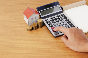 Calculating with Coins stack and paper house and notepad