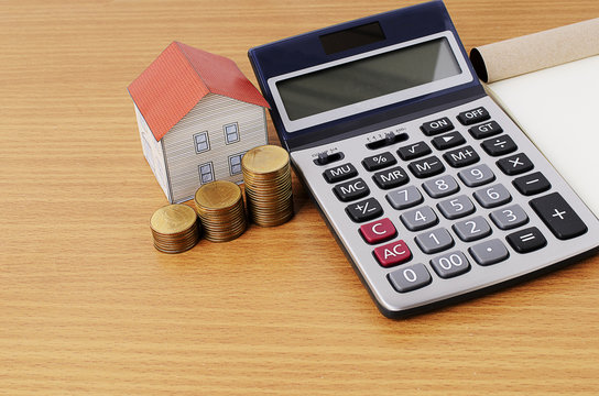Mortgage loans concept with calculator and coins stack and paper