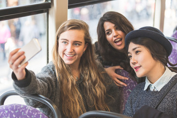 Three womentaking a selfie in the bus