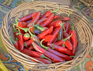 Small red peppers in a wood backet