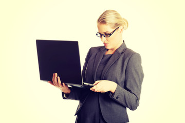 Businesswoman standing and holding a laptop