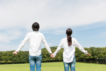 手をつないで歩く男女カップル