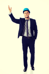 Businessman in hard hat showing copyspace.