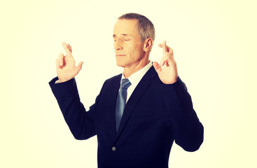 Businessman making a wish with fingers crossed