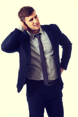 Annoyed businessman covering his ear.