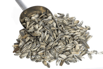 Sunflower seeds with measuring scoop on white background