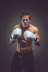 Fototapeta na wymiar Muscular boxer in white gloves.