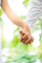 A young couple holding hands in the park, London.