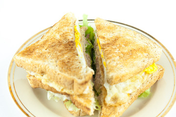 Sandwich full of tuna and lettuce vegetables sliced in half - Closeup