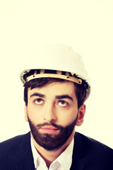 Young man with hard hat looking up.