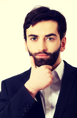 Young handsome businessman with hand under chin.