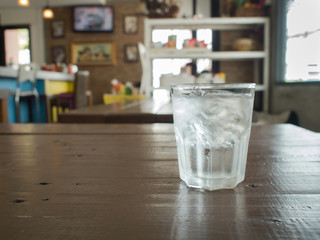 Glass of cool  water with ice on wood table