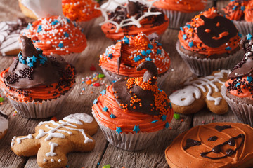 Halloween cupcakes and gingerbread cookies close-up. Horizontal
