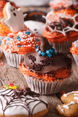 Halloween cupcakes with ghosts and witch hat close-up. vertical
