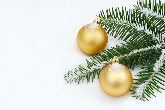 Goldene  Weihnachtskugeln im Schnee