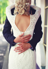 Wedding elegant couple hugging, view of back, lace bridal dress, bride and groom close up 