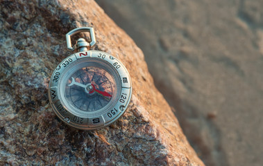 Compass on the beach. Tourist equipment as a background