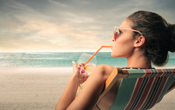 Woman drinking at the beach