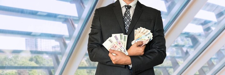 Businessman in suit with Czech and European money