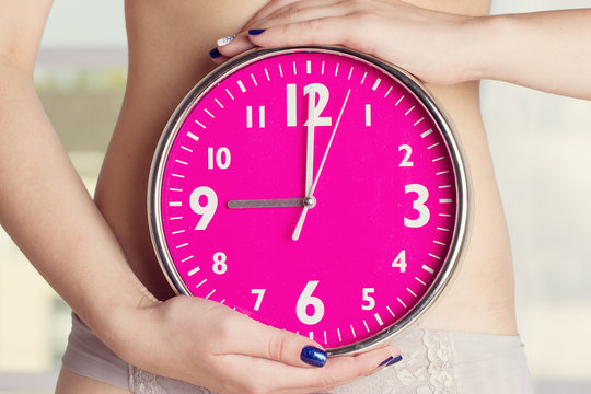 Biological clock ticking - Pink watches in female hands. toning