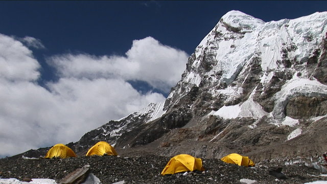 Climber walking to and entering tent under Pumori