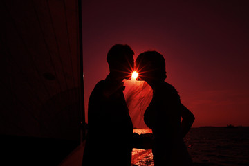 newlyweds kiss against the setting sun - 91813317