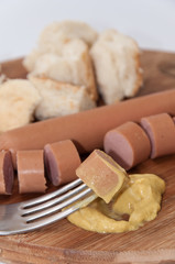 Hot dog with mustard on the fork