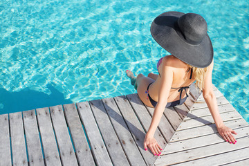 Woman sitting on the deck by the pool