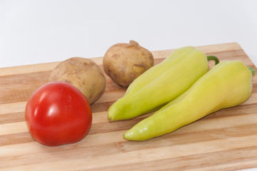 Tomato potato and green paprika on the wooden board