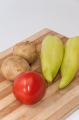 Tomato potato and green paprika on the wooden board
