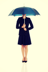 Business woman is holding blue umbrella. 