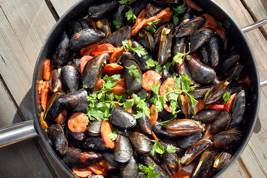 Mussels with chorizo cooking in a pan