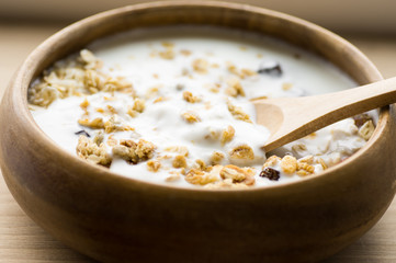 Muesli with milk in a rustic wooden bowl