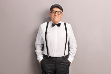 Senior in artistic clothes posing in front of a wall