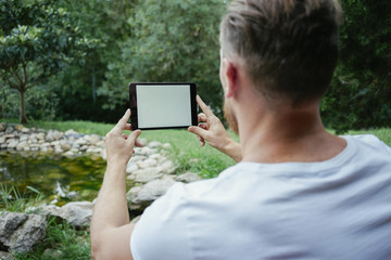 Man using digital tablet in the park