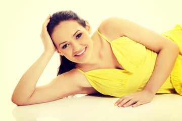 Beautiful woman lying in yellow dress.