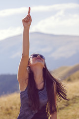 beautiful and happy woman pointing skyward