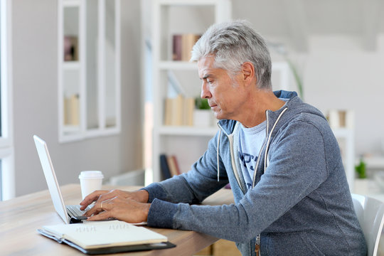 Senior man working from home on laptop computer