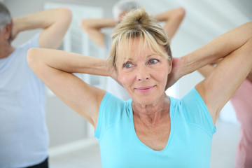 Senior people stretching out in fitness room