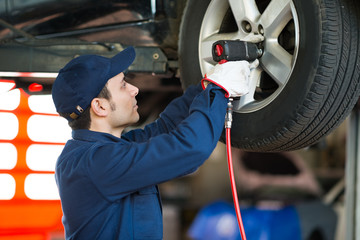 Mechanician changing a wheel in auto repair shop