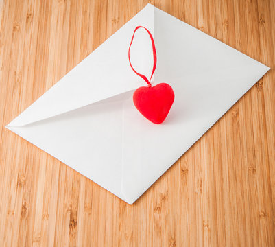 envelope with a heart on a wooden background