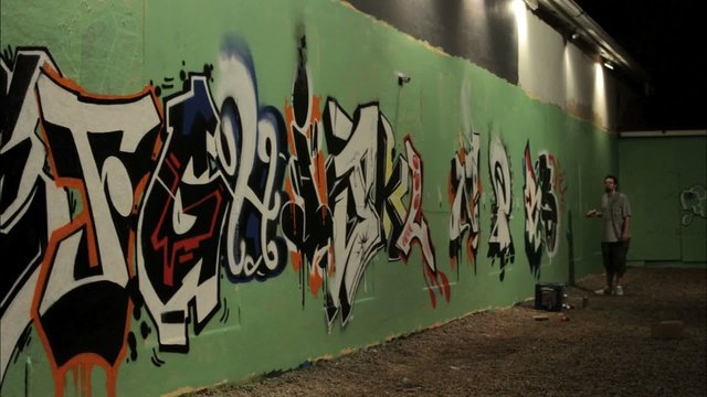 Time lapse shot of graffiti being sprayed on a wall by taggers.