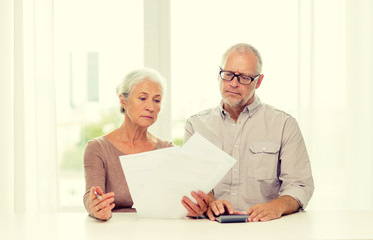 senior couple with papers and calculator at home