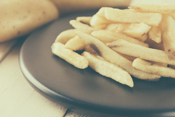 french fries on wood background - soft focus with vintage film f