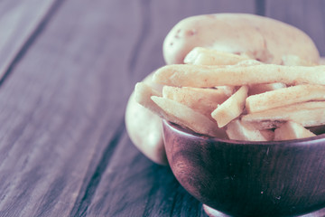 french fries on wood background - soft focus with vintage film f