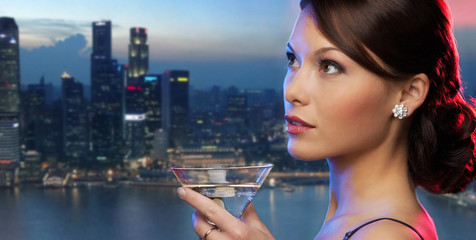 Fototapeta premium smiling woman holding cocktail over night city